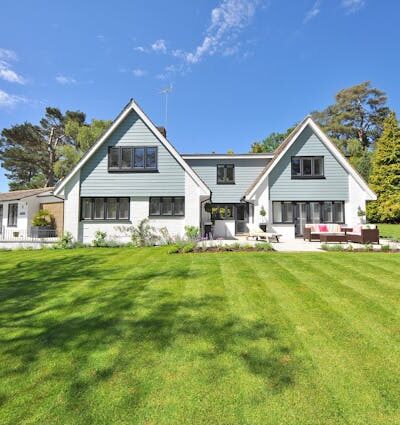 White and Gray Wooden House Near Grass Field and Trees