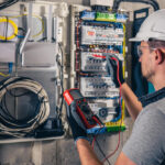 electrical technician working in a switchboard with fuses