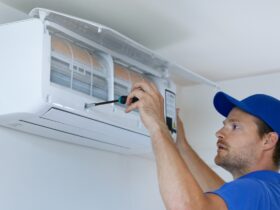 Specialist cleans and repairs the wall air conditioner