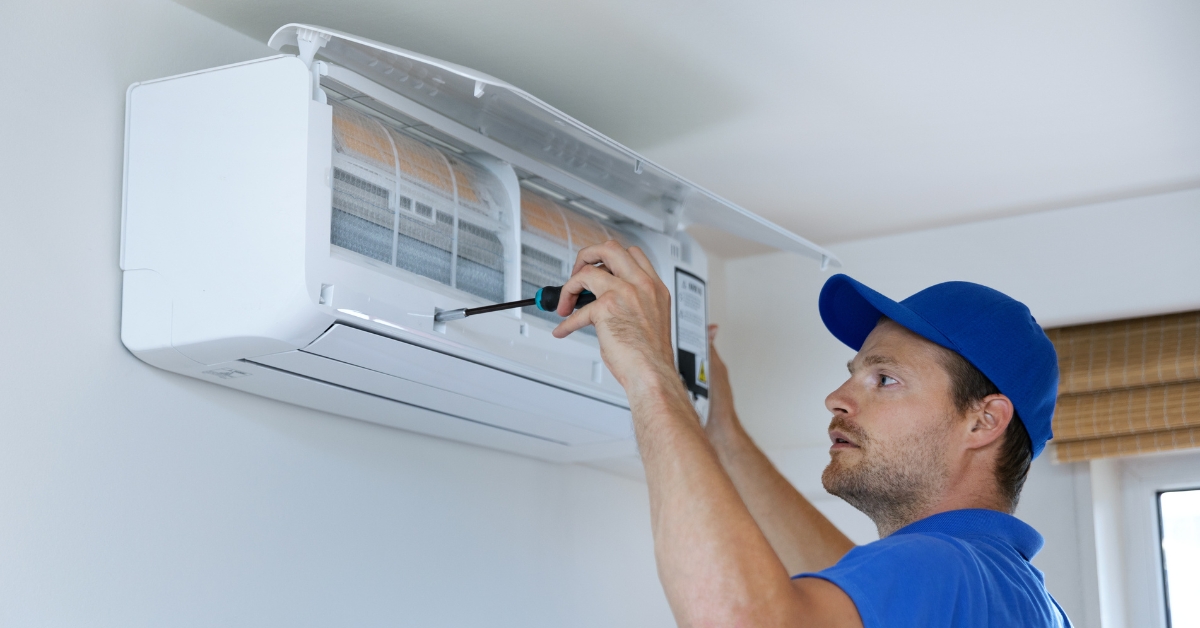 Specialist cleans and repairs the wall air conditioner