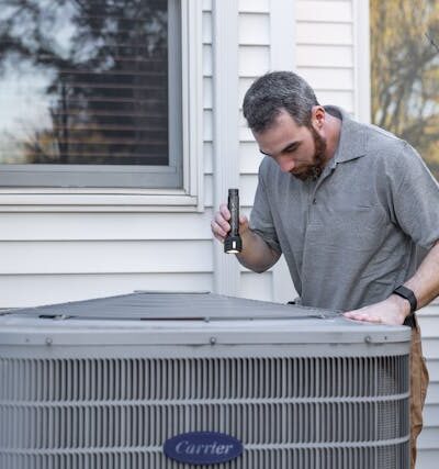 Technician Inspecting Outdoor HVAC Unit