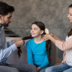 Parents brushing daughter hair