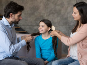 Parents brushing daughter hair