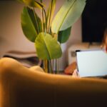 a woman sitting on a couch using a laptop computer