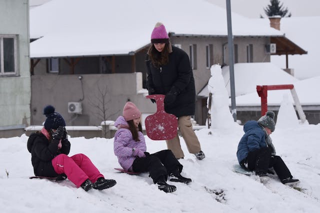 Children Sledding in Snowy